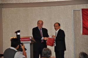 IU President McRobbie gives a gift to Phillip Chua, who leads the university's Singapore alumni chapter.