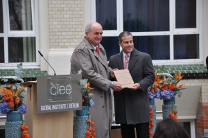 President McRobbie receives a cardboard etching of the new Global Institute from CIEE President and CEO James Pellow.