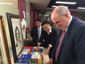 IU President Michael McRobbie surveys a collection of photos and works related to the late IU Nobel Laureate Elinor Ostrom. 